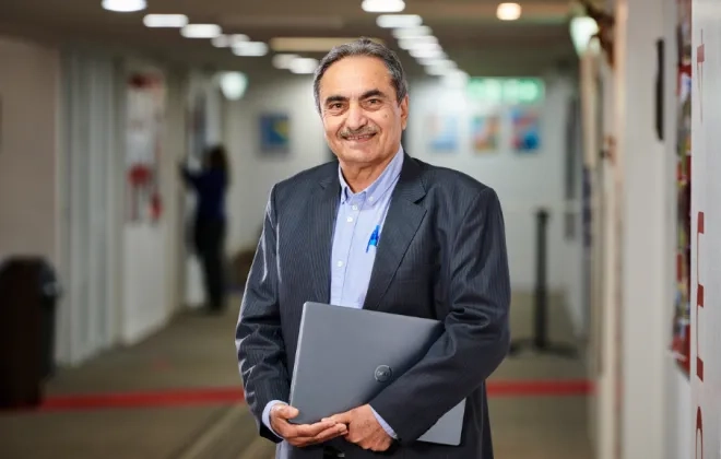 Man holding file in hand looking at camera and smiling