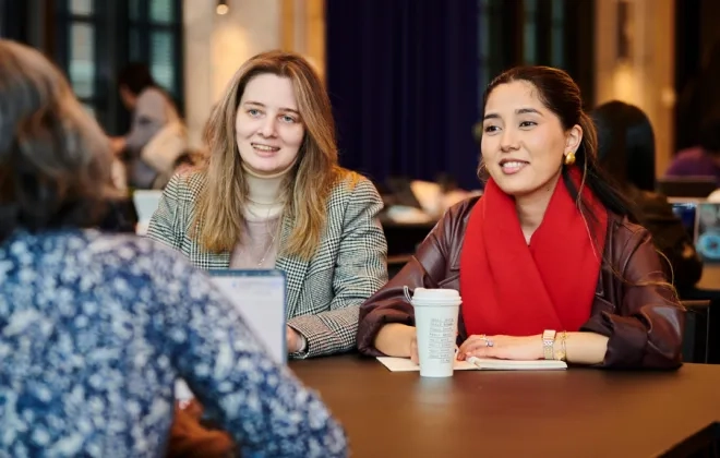 Two women talking to a third woman