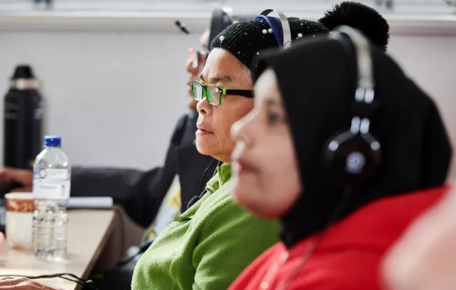 Women with headphone in front of computers