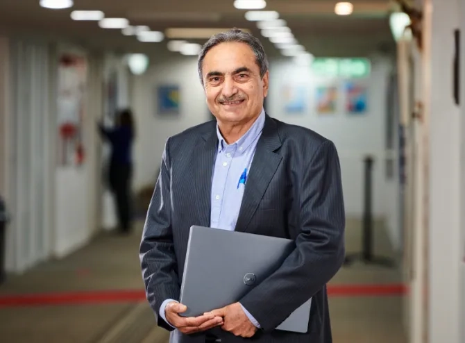 Man holding file in hand looking at camera and smiling