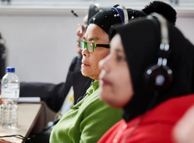 Women with headphone in front of computers